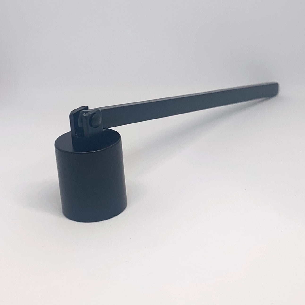Black candle snuffer against white backdrop