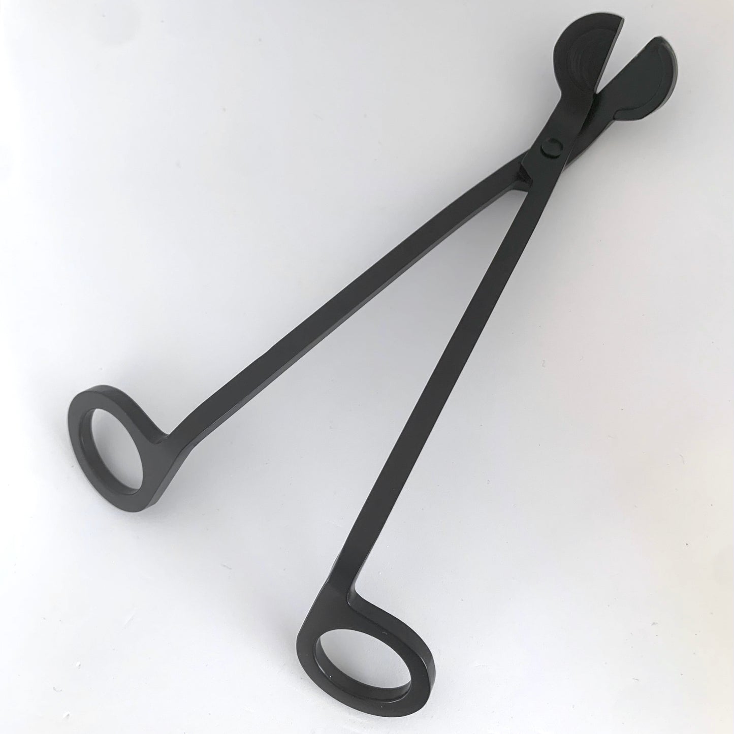 Black candle wick trimmer against white backdrop