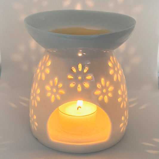 Ceramic White Daisy Wax Burner with lit tealight, against a white background.
